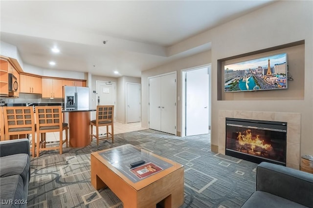 living room with dark carpet and a fireplace