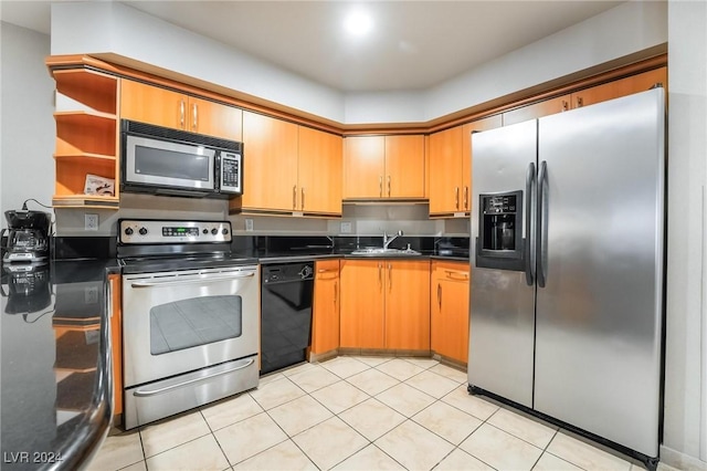 kitchen with appliances with stainless steel finishes, light tile patterned floors, and sink