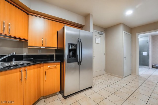 kitchen with stainless steel fridge, sink, and light tile patterned floors