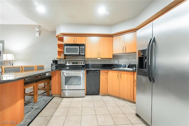 kitchen with light tile patterned floors, sink, and appliances with stainless steel finishes