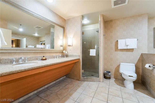 bathroom with toilet, vanity, tile patterned floors, and a shower with shower door