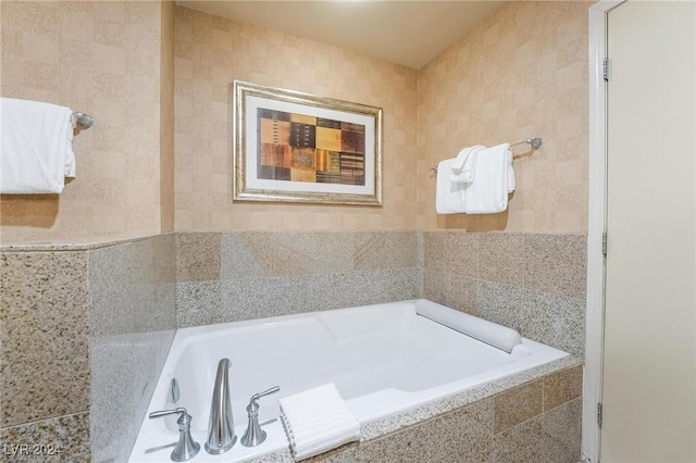 bathroom with a relaxing tiled tub and tile walls