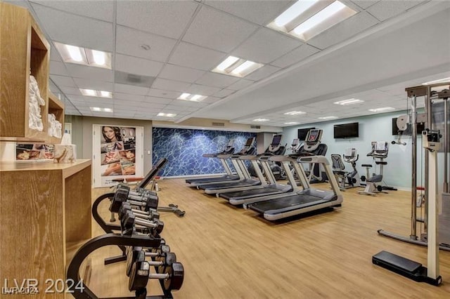 gym with a paneled ceiling and hardwood / wood-style flooring