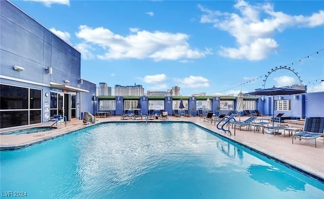 view of swimming pool featuring a patio and a hot tub