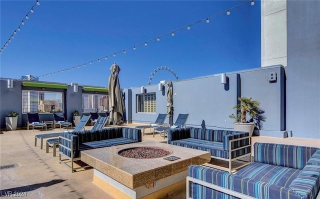 view of patio with an outdoor living space with a fire pit