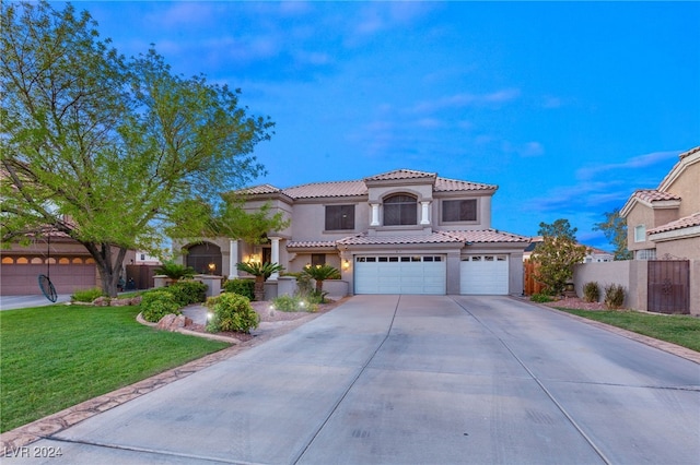 mediterranean / spanish home with a garage and a front lawn