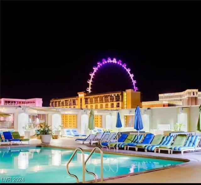 pool at twilight featuring a patio area