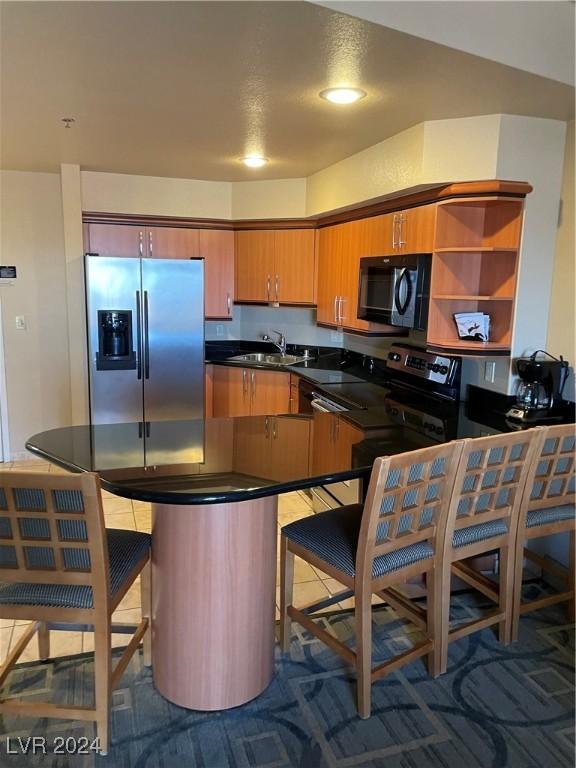 211 E Flamingo Rd Unit 614, Las Vegas, NV 89169 - kitchen featuring stainless steel fridge with ice dispenser, black microwave, dark countertops, open shelves, and brown cabinets