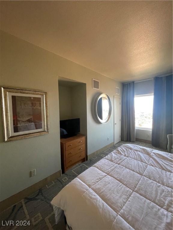 bedroom with carpet and a textured ceiling