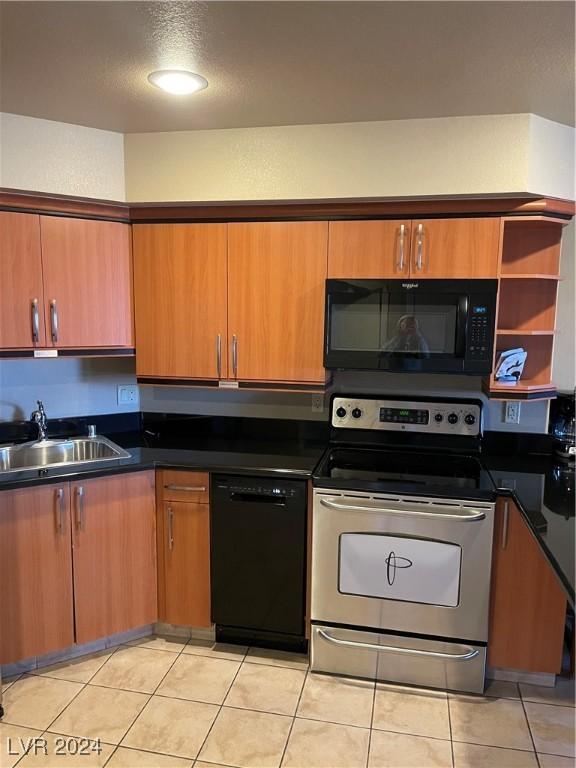 211 E Flamingo Rd Unit 614, Las Vegas, NV 89169 - kitchen with black appliances, dark countertops, light tile patterned floors, and brown cabinets