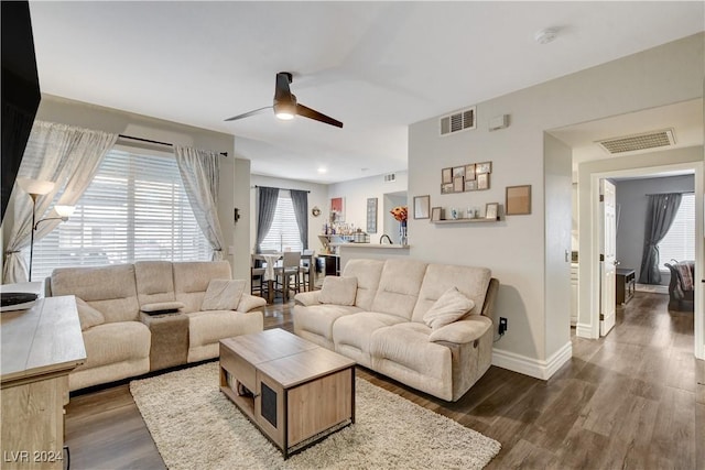 living room with dark hardwood / wood-style floors, a healthy amount of sunlight, and ceiling fan