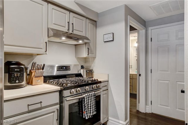 kitchen with white cabinets, dark hardwood / wood-style flooring, and gas stove