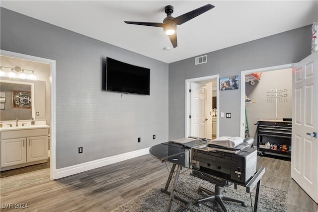 office space featuring hardwood / wood-style floors, ceiling fan, and sink