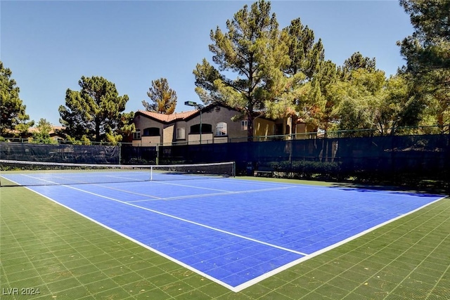 view of tennis court with basketball hoop