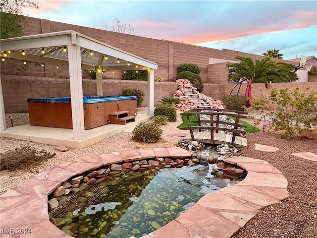 view of patio with a fenced backyard and a hot tub