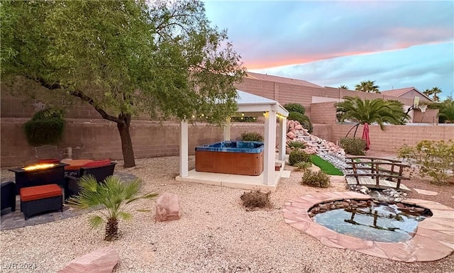 view of patio featuring outdoor dining space, a fenced backyard, and a hot tub