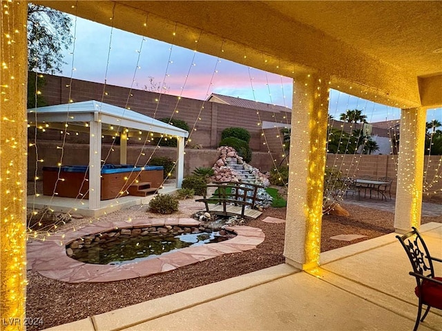 patio terrace at dusk with a hot tub