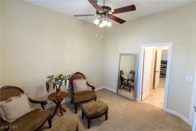 living area featuring light carpet and ceiling fan