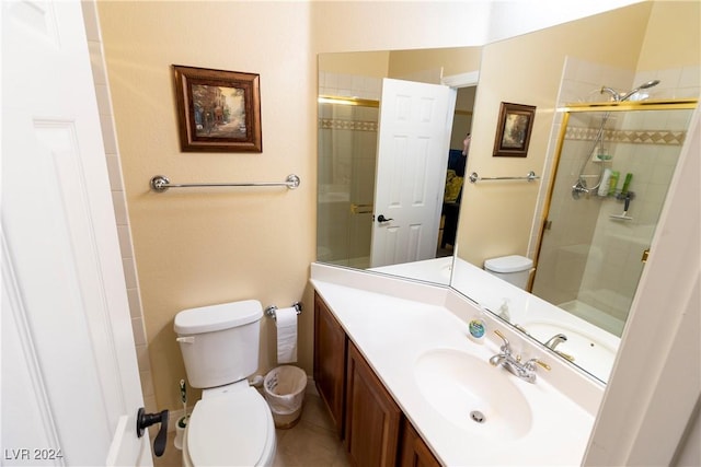 bathroom with a tile shower, vanity, and toilet