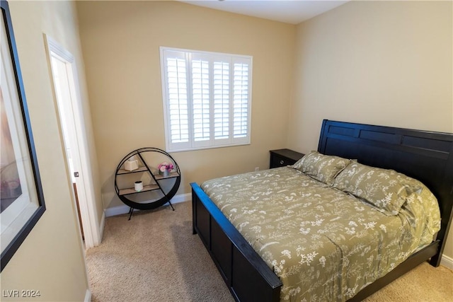 bedroom with light carpet and baseboards