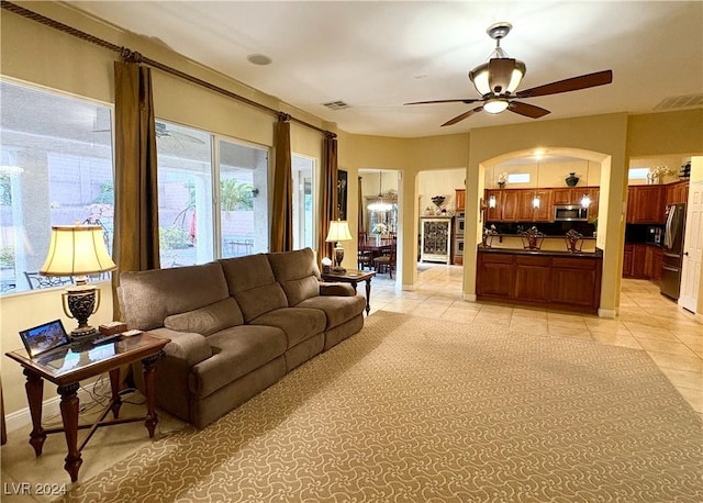 living room featuring ceiling fan, visible vents, baseboards, and light tile patterned flooring