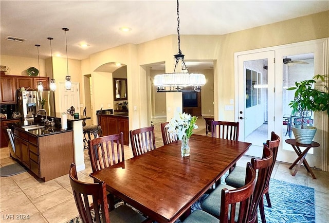 dining area with arched walkways, light tile patterned floors, and visible vents