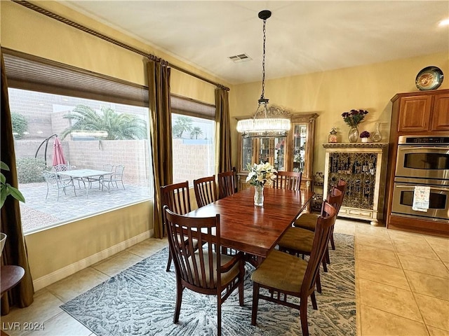 tiled dining space with an inviting chandelier