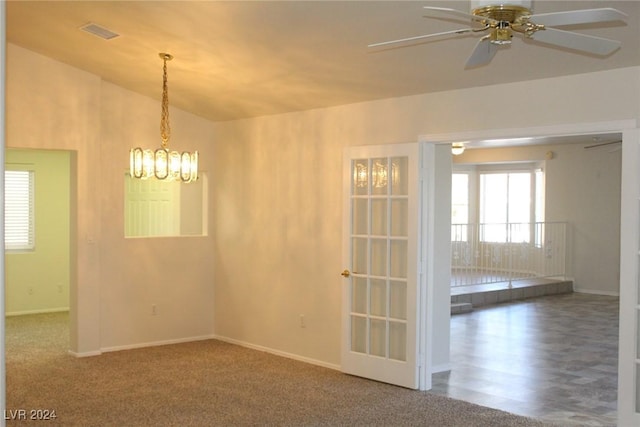 unfurnished room featuring vaulted ceiling, carpet, and ceiling fan with notable chandelier