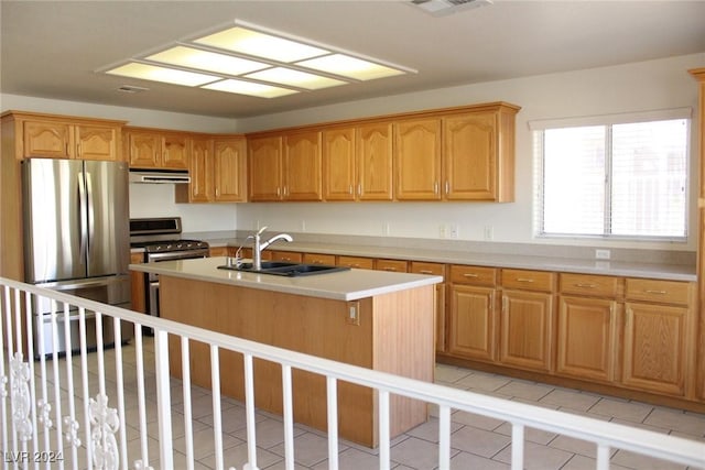 kitchen featuring a center island with sink, sink, light tile patterned floors, and stainless steel appliances