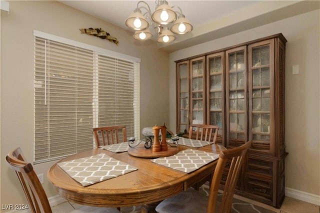 dining area featuring tile patterned floors and an inviting chandelier