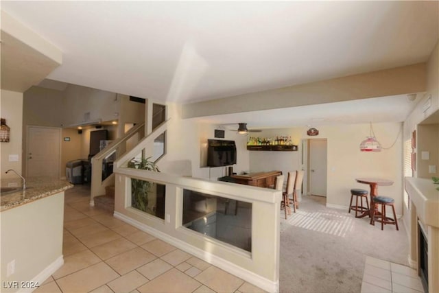 interior space with ceiling fan, light tile patterned floors, and sink