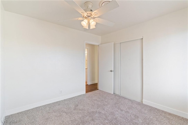 unfurnished bedroom featuring carpet, a closet, and ceiling fan