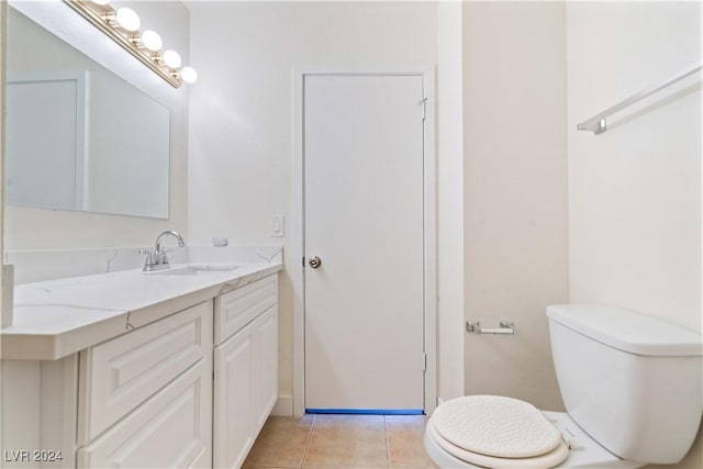 bathroom featuring tile patterned flooring, vanity, and toilet