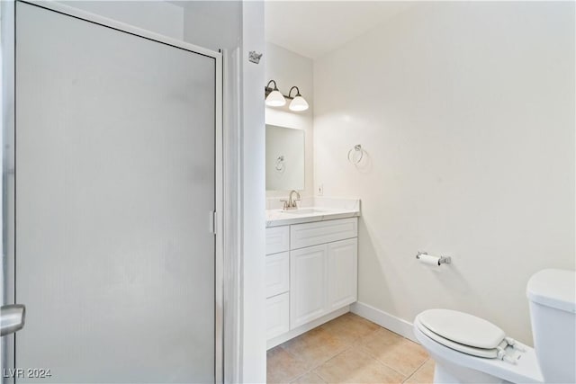 bathroom featuring toilet, vanity, tile patterned floors, and walk in shower