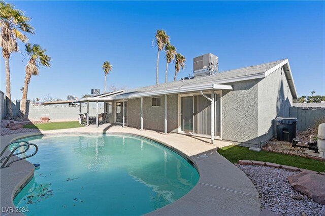 view of swimming pool with central air condition unit and a patio