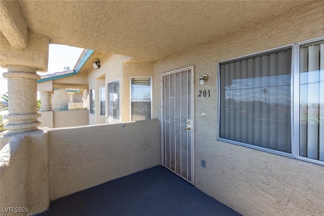 view of exterior entry featuring a balcony