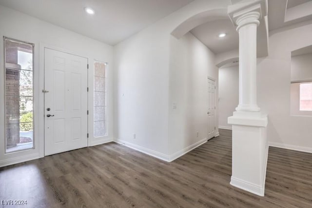 foyer entrance featuring decorative columns and dark wood-type flooring