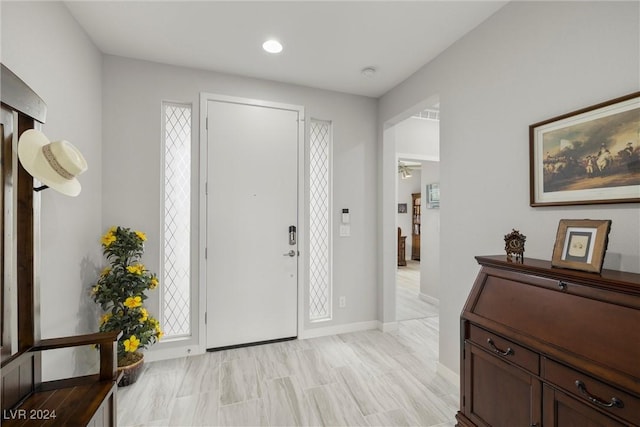 foyer entrance with ceiling fan and a wealth of natural light