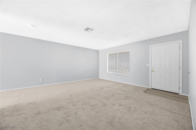 carpeted spare room featuring a textured ceiling