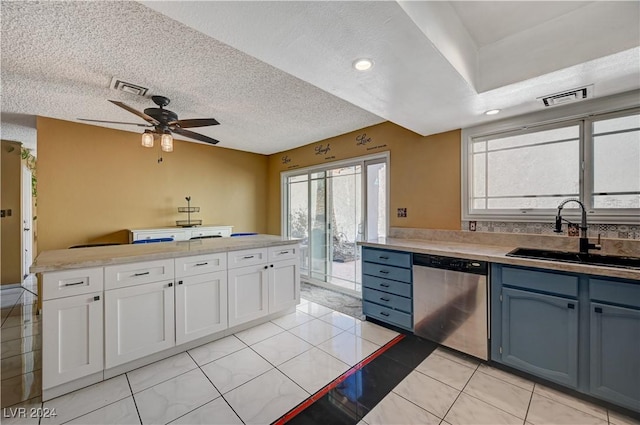 kitchen with white cabinets, sink, stainless steel dishwasher, a textured ceiling, and a wealth of natural light