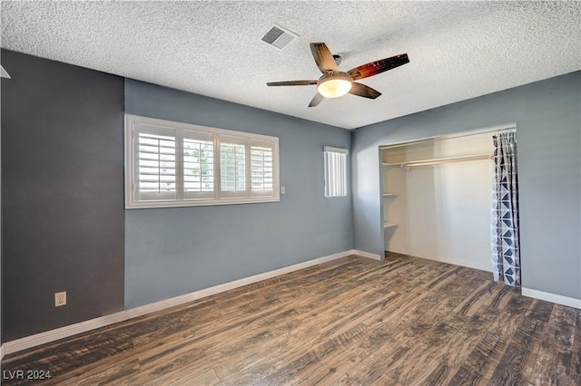 unfurnished bedroom with ceiling fan, dark hardwood / wood-style flooring, a textured ceiling, and a closet