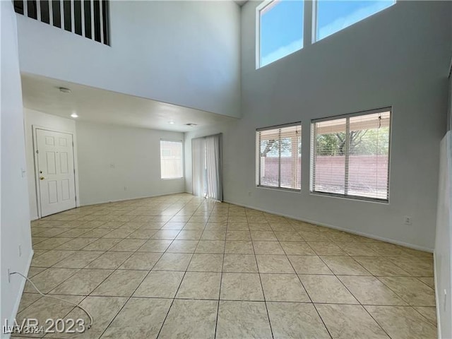 interior space featuring a wealth of natural light, a towering ceiling, and light tile patterned floors