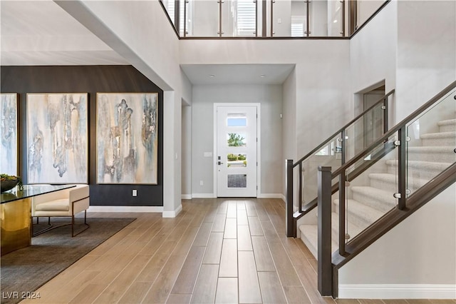 foyer featuring wood-type flooring and a towering ceiling