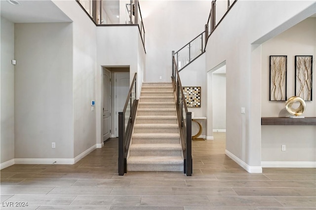 staircase featuring hardwood / wood-style floors and a high ceiling