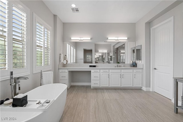 bathroom featuring hardwood / wood-style floors, vanity, and a bath