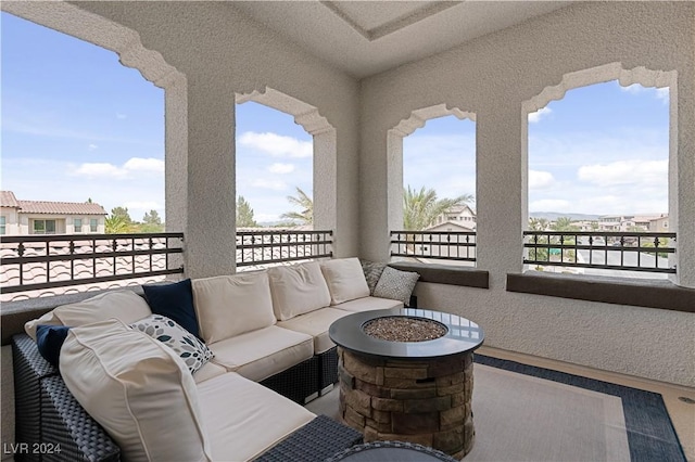 balcony featuring an outdoor living space with a fire pit