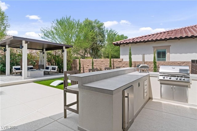 view of patio / terrace featuring area for grilling, a bar, and grilling area