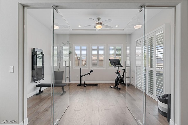 workout room with ceiling fan and wood-type flooring