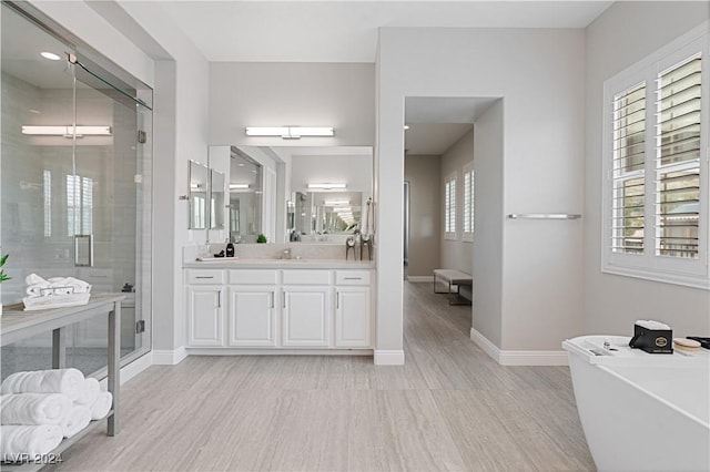 bathroom with hardwood / wood-style floors, vanity, and separate shower and tub