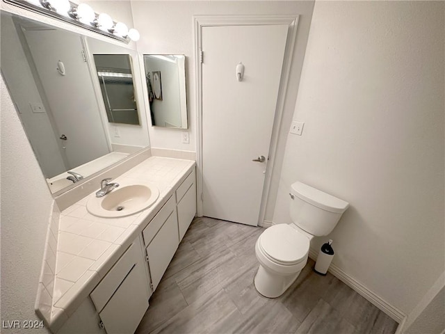 bathroom featuring vanity, toilet, and wood-type flooring